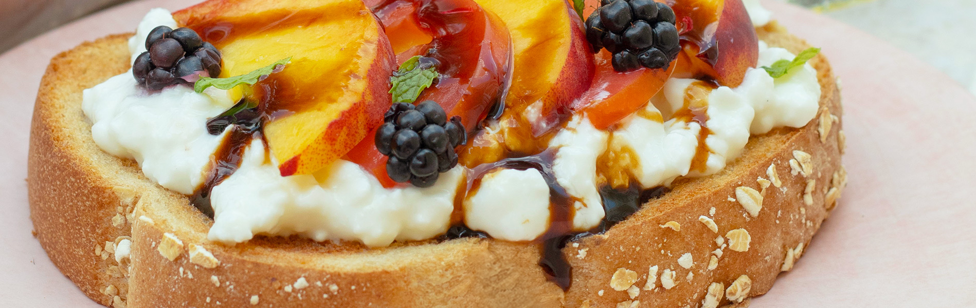 Toast with cottage cheese, peaches, tomatoes, blackberries, balsamic glaze and mint on Artesnao Smooth Multigrain Bread